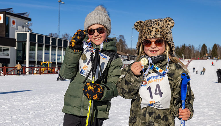 Två barn med medalj på Barnens skidspel