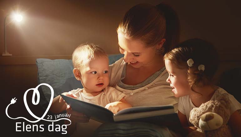 mamma läser bok för två barn med en tänd lampa vid sidan om